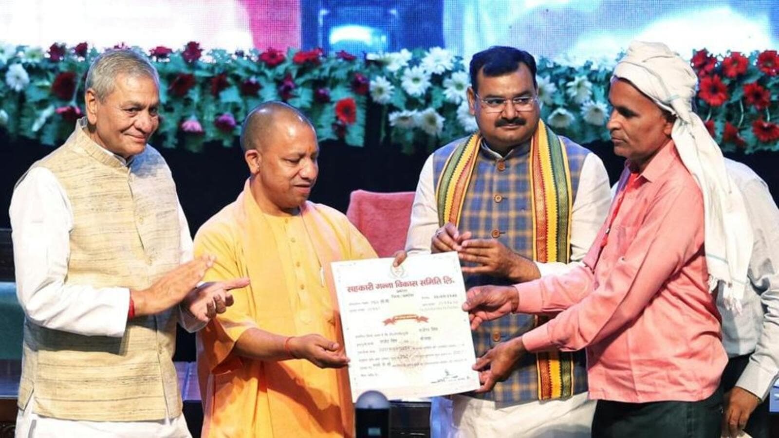 Yogi distributes share certificates to farmers