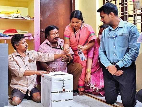 Election officials facilitate a person with disability cast his vote in Hyderabad