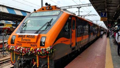 Amrit Bharat Express train parked at railway station platform with passengers and staff nearby