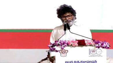Trivikram Srinivas speaking at a podium during Andhra University centenary celebrations in front of audience