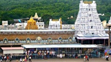 Devotees walking under shaded shelters at Tirumala temple during hot summer weather