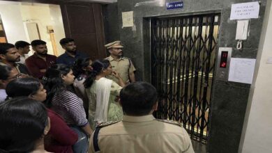 Police officers and residents standing near a hostel lift in Gachibowli during investigation into a child death accident.