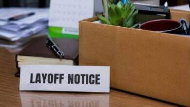 Office desk with layoff notice and packed employee belongings representing global technology company job cuts