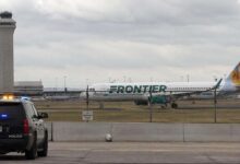 Police vehicle near Frontier Airlines aircraft at Denver International Airport after runway emergency incident