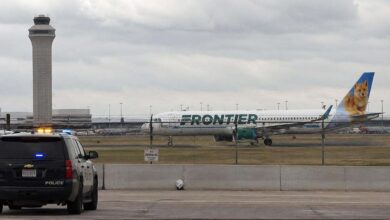 Police vehicle near Frontier Airlines aircraft at Denver International Airport after runway emergency incident