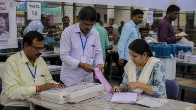 Election officials counting votes at a busy counting center during five states election results day in India