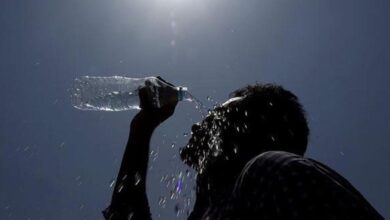 Person covering face with scarf while walking under extreme summer heat during rising temperatures in Hyderabad