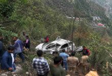 Rescue teams and local people near a crashed car after a fatal road accident in Nainital where a vehicle fell into a deep gorge causing multiple deaths