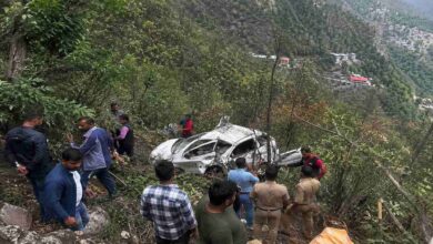Rescue teams and local people near a crashed car after a fatal road accident in Nainital where a vehicle fell into a deep gorge causing multiple deaths