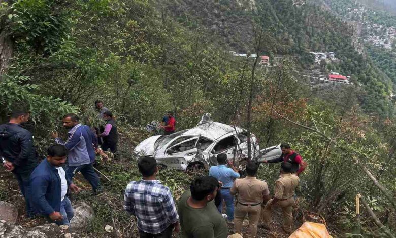 Rescue teams and local people near a crashed car after a fatal road accident in Nainital where a vehicle fell into a deep gorge causing multiple deaths