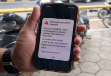 Smartphone showing emergency alert test message during nationwide mobile siren alert system trial for disaster preparedness in India
