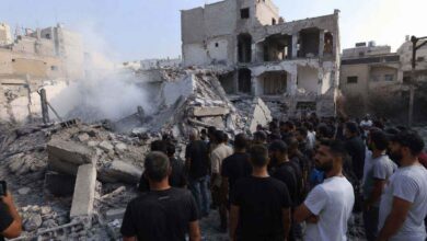 People standing near damaged buildings and debris in South Lebanon following airstrikes and conflict related destruction