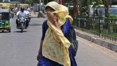 Woman covering her face while walking under intense summer heat during Telangana heatwave conditions and red alert warning news update